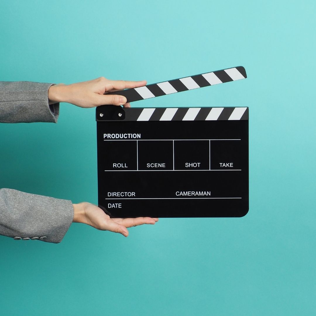 Person holding a clapperboard highlighting video marketing services.