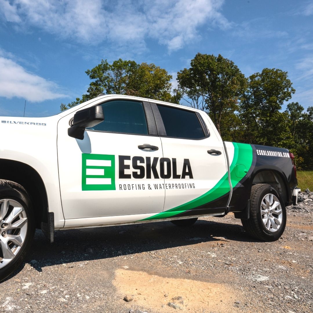 Eskola Roofing branded white and green vehicle wrap on a pickup truck.